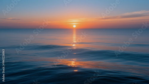 Fototapeta Naklejka Na Ścianę i Meble -  A serene and beautiful ocean sunset captures the warmth of the sun as its reflection dances on the water under a vibrant sky reflecting peace