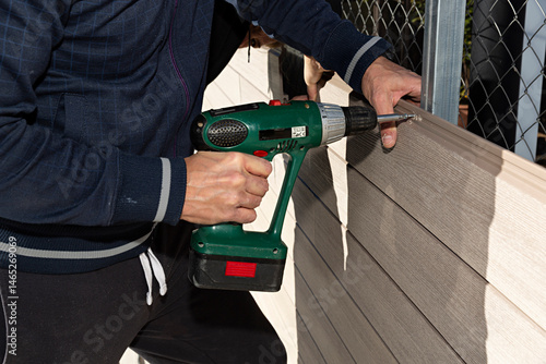 Hombre trabajando en la construcción de una valla de composite.
