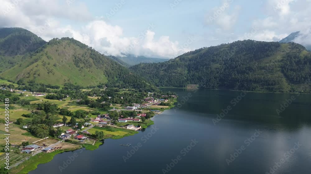 Lakeside village with green hills view Lakeside village with green hills view