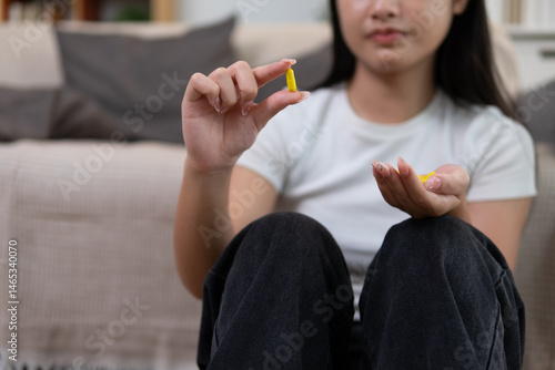 A pill in the hand of a young woman who is about to take it to relieve symptoms.