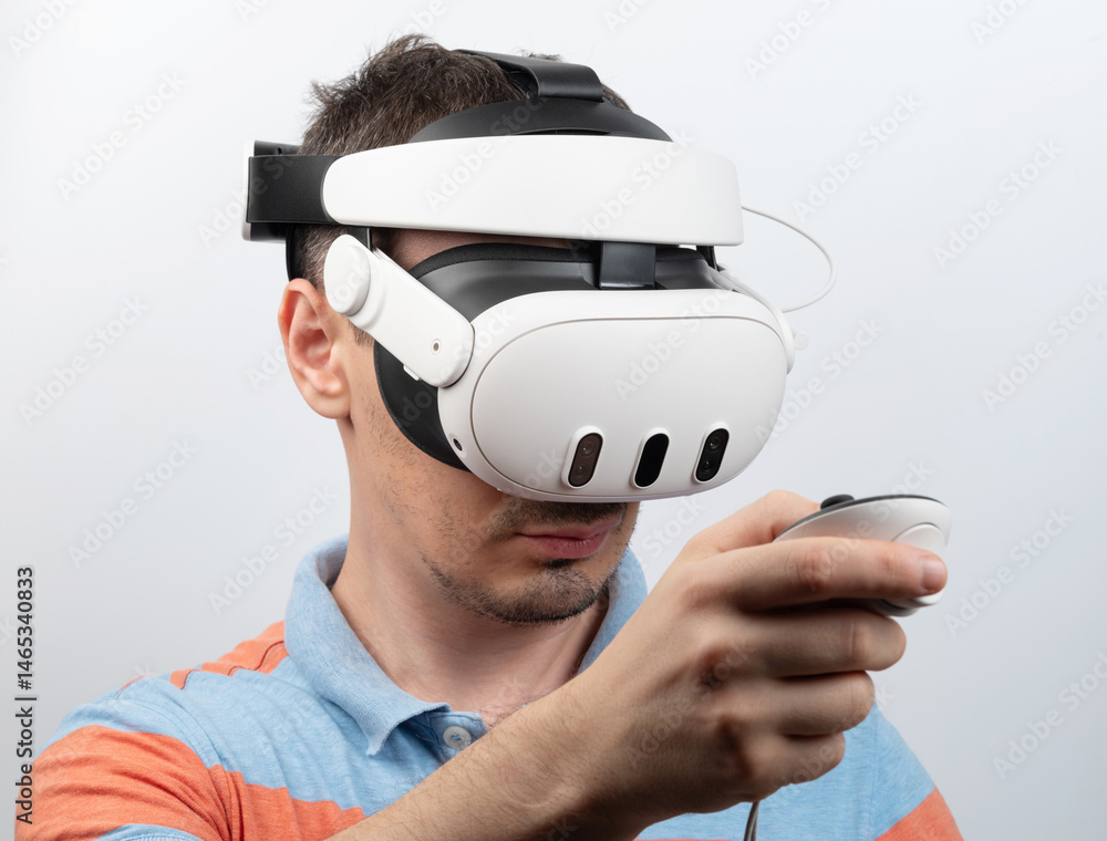 Man experiences virtual reality in bright indoor setting while holding controller