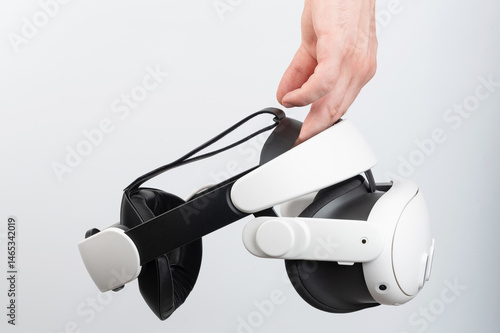 Obraz na płótnie Innovative virtual reality headset being held by hand in modern, minimalist setting w salonie