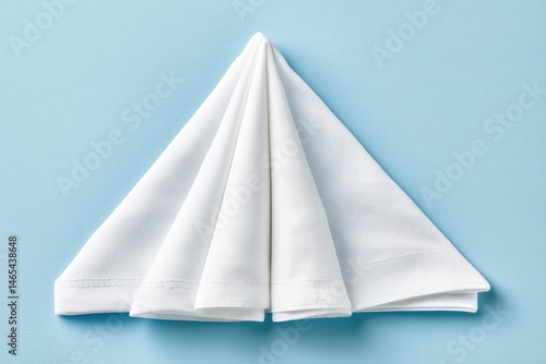 Obraz na płótnie White Flag Elegantly Folded Into a Triangular Shape Against a Light Blue Background, Symbolizing Peace and Surrender w salonie