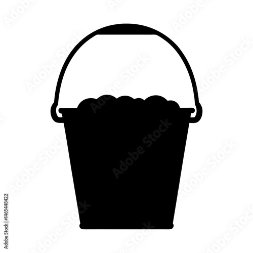 A black silhouette of a bucket filled with items, possibly sand or pebbles, featuring a simple handle on top