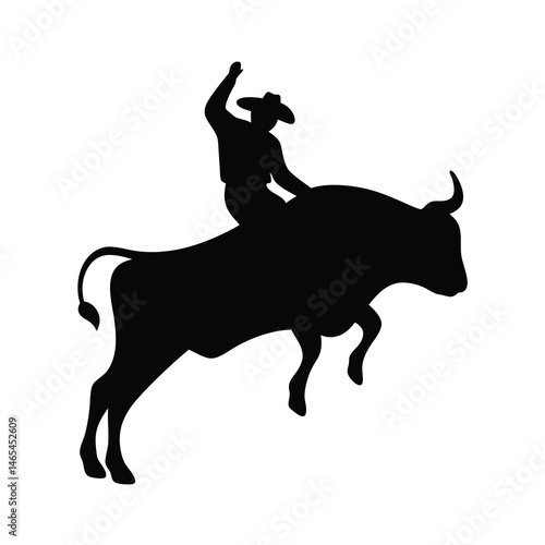 Silhouette of a cowboy riding a bucking bull in a rodeo competition