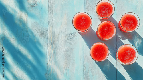 Obraz na płótnie Vibrant and chilled watermelon smoothies in glasses set against a light blue wooden surface, leaving space for text w salonie