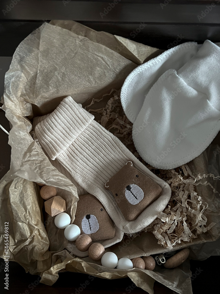 Socks, white scratches, a rodent elephant, beads. A set of accessories and toys for newborns in a pull-out shelf in the bedside table
