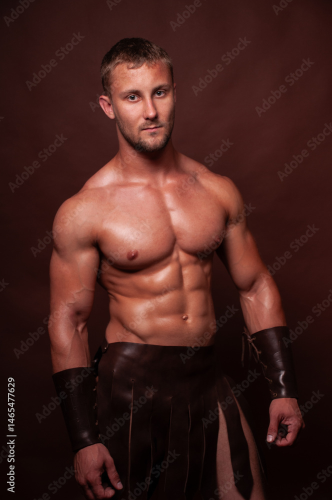 Strong Gladiator Warrior in Leather Armor Posing in Studio Strong Gladiator Warrior in Leather Armor Posing in Studio