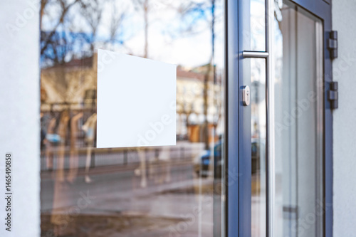 Blank white box signboard mockup on glass door.