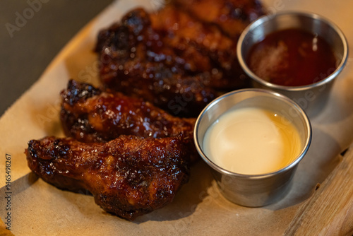 Closeup of chicken wings with dips served at restaurant