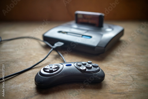 A vintage video game console with a connected gamepad.Games from the 90s.