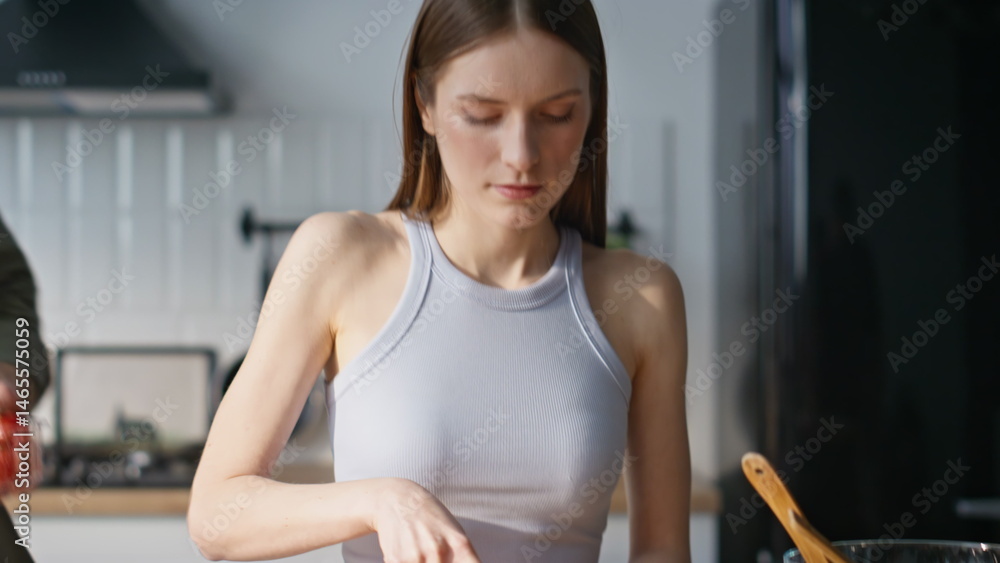 Housewife chopping fresh vegetables in kitchen countertop. Smiling husband wife