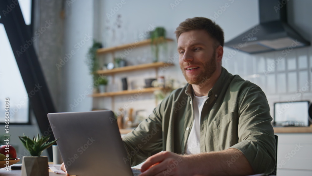 Smiling entrepreneur video meeting looking laptop web camera in kitchen closeup