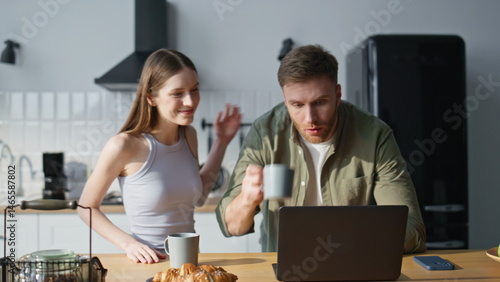 Obraz na płótnie Hurrying husband kissing wife bringing coffee cups at home kitchen closeup. w salonie