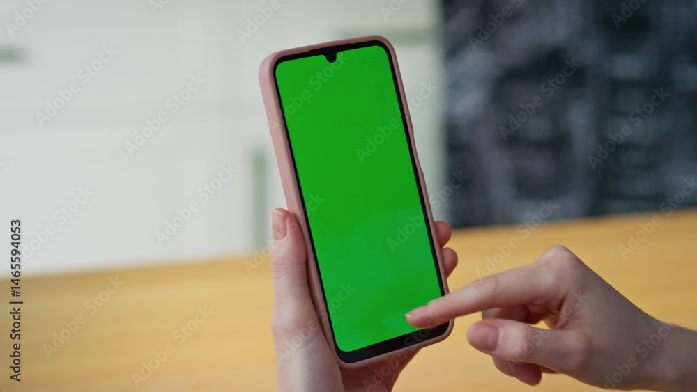 Girl fingers scrolling mockup smartphone browsing app in apartment closeup.
