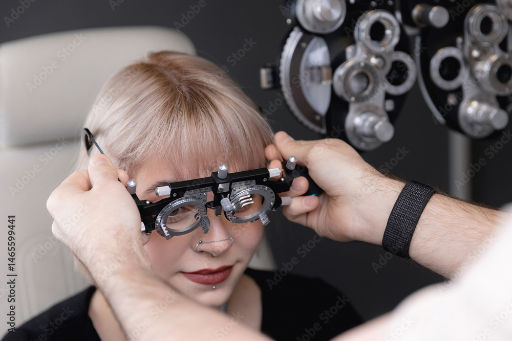 Young caucasian female eye exam with phoropter in optometry clinic setting