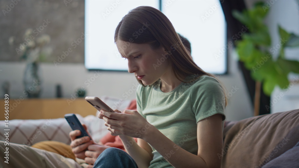 Troubled family receiving message on mobile phone in living room home closeup.