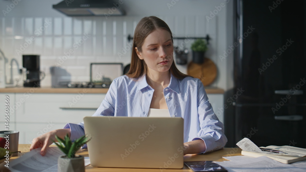 Busy woman dissatisfied paperwork working laptop in modern home office closeup.