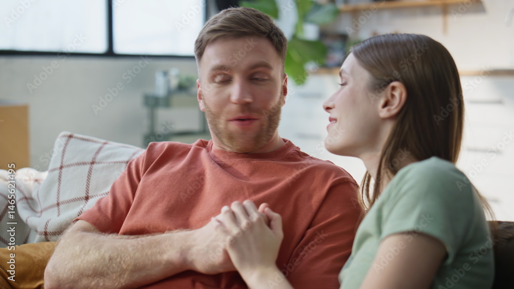 Fototapeta premium Romantic couple talking couch home closeup. Smiling spouses bonding laughing