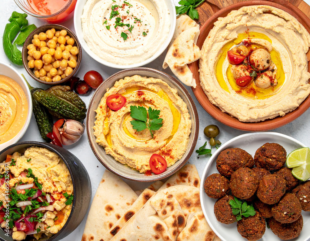 A vibrant spread of Middle Eastern food, including hummus, pita bread, and falafel, representing the diverse culinary landscape of Israel. A vibrant spread of Middle Eastern food, including hummus, pita bread, and falafel, representing the diverse culinary landscape of Israel.