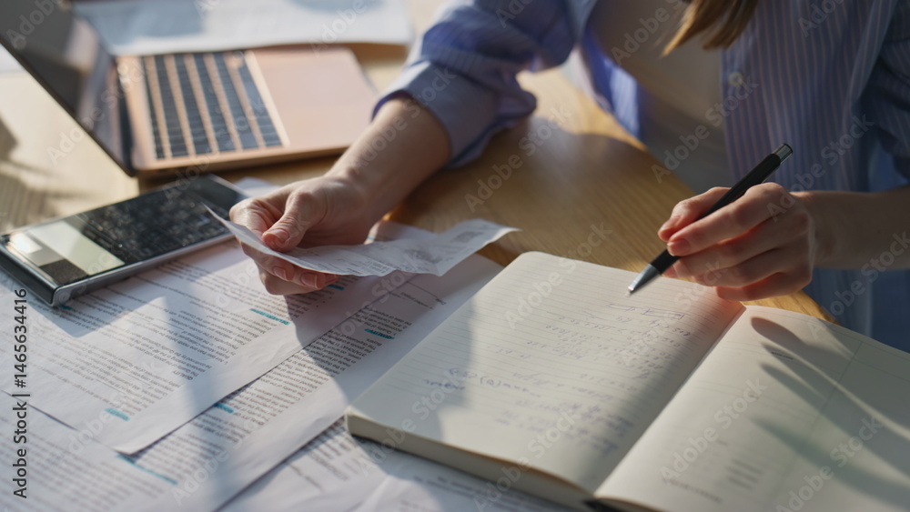 Woman hands calculating finances expenditures checking notes in notebook closeup