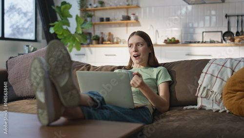 Obraz na płótnie Home girl videocalling laptop lying comfortable apartment sofa with coffee cup. w salonie