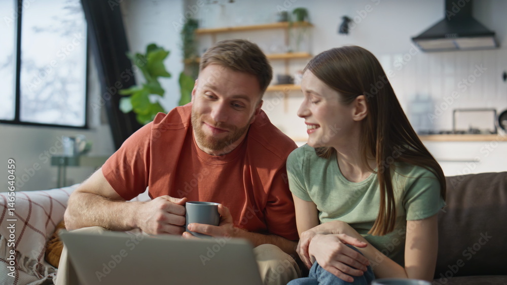Spouses enjoy online meeting with family using laptop internet at home closeup