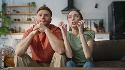 Anxious two fans watching TV championship at home sofa closeup. Tensed woman man