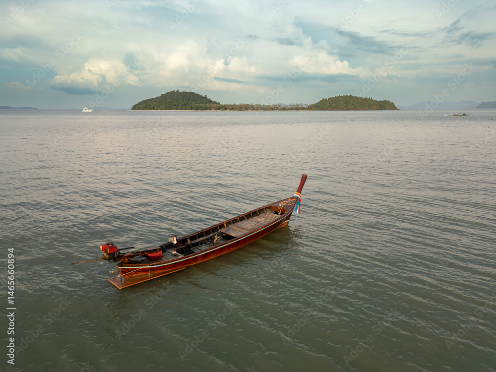 Aerial view of wooden sailboats anchored near a tropical island coastline, picturesque seaside scene featuring boats on blue water close to the shoreline beach. Exotic landscape.