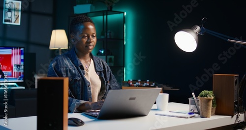 Focused freelancer working from home, typing on laptop, writing in document. Remote employee scrolling on digital device and sending emails to business associates, camera B close up