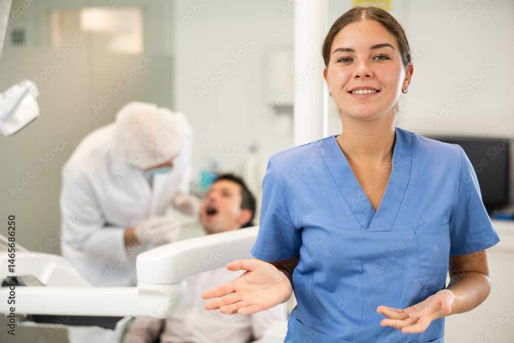 Fototapeta premium In dentists office, girl nurse before start of appointment and working day. Positive medical specialist welcomes clinics clients. Doctor enjoys working in profession. Patient treatment in background