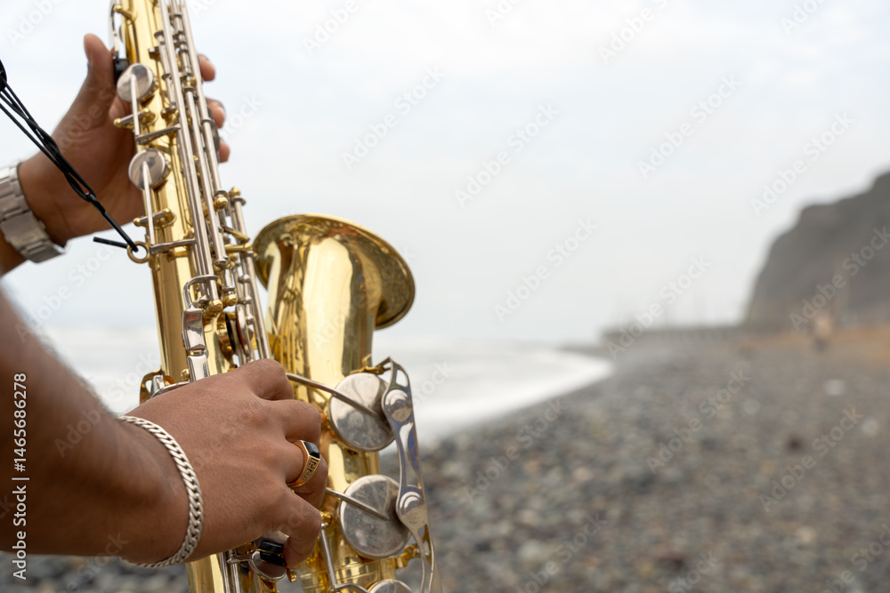 Obraz premium Saxophonist playing sax on the beach seeking inspiration
