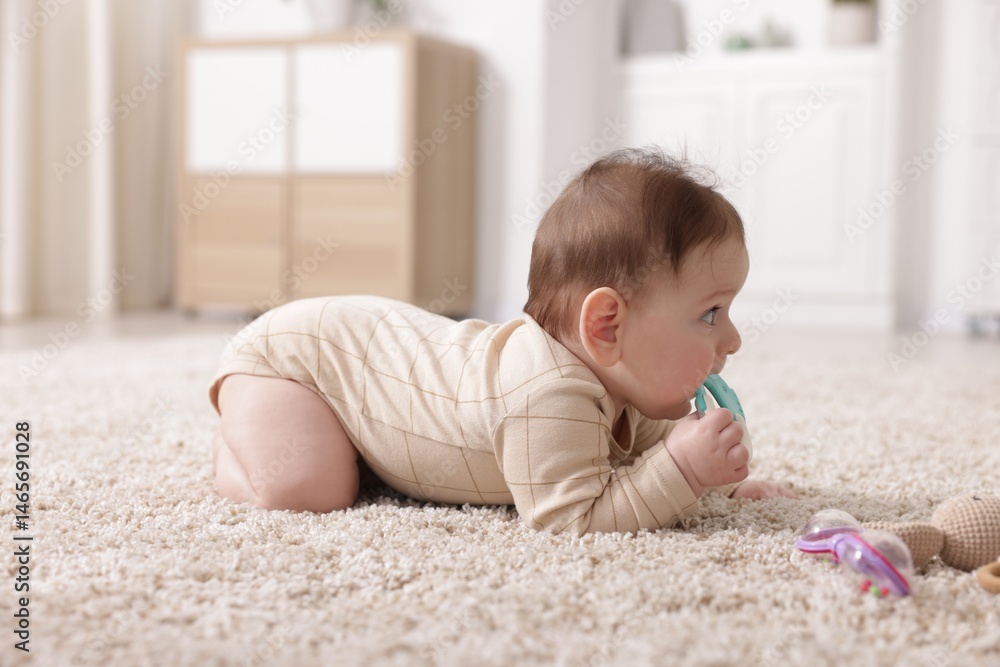 Cute little baby with rattle toy on floor at home Cute little baby with rattle toy on floor at home
