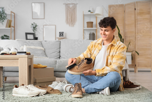 Young man cleaning boot wit...