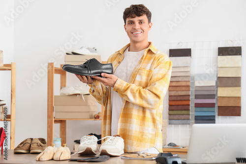 Male shoemaker with shoes i...