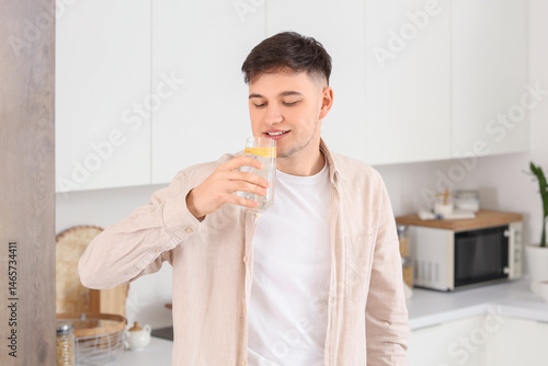 Young man drinking lemon in...