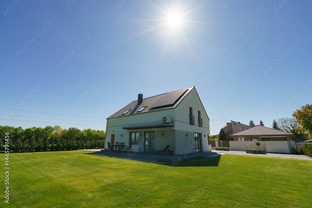 New build fully detached house with solar panels under sunlight beams