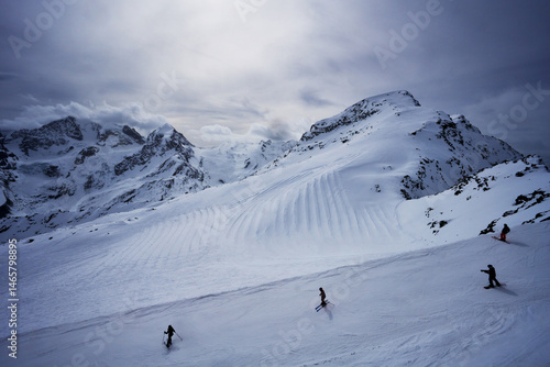 Skiers and snowboarders coming down Piz Corvatsch mountain, Switzerland, Europe  photo
