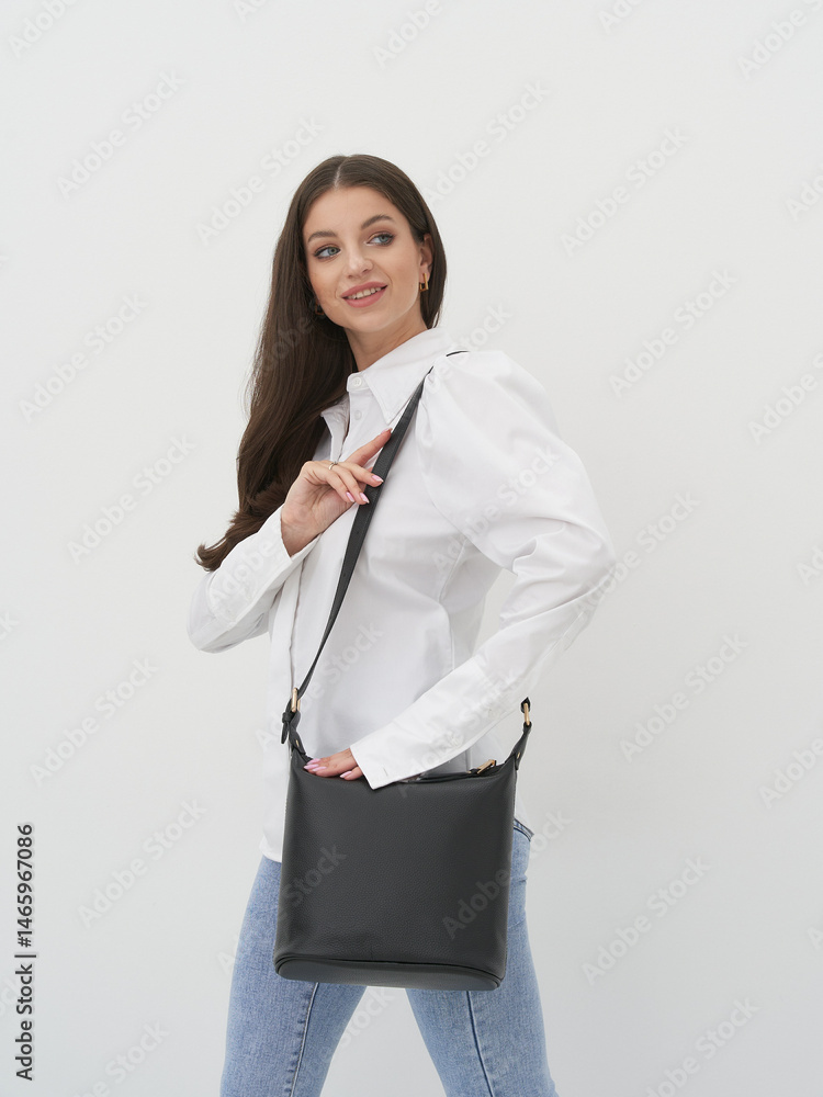 Elegant model showcasing a chic bag in a contemporary studio setting Elegant model showcasing a chic bag in a contemporary studio setting