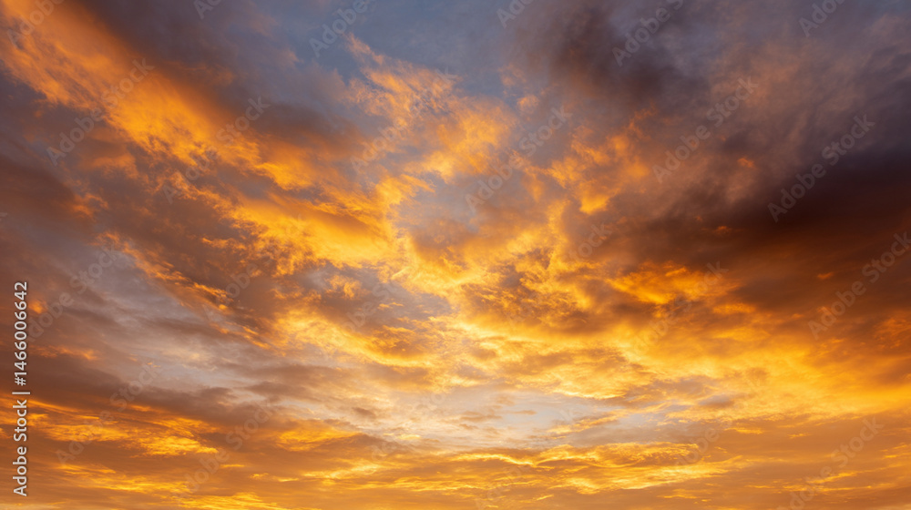 Fototapeta premium Golden sky at sunrise with dramatic clouds, warm sunlight, and peaceful atmosphere, perfect for nature backgrounds or tranquil landscape scenes