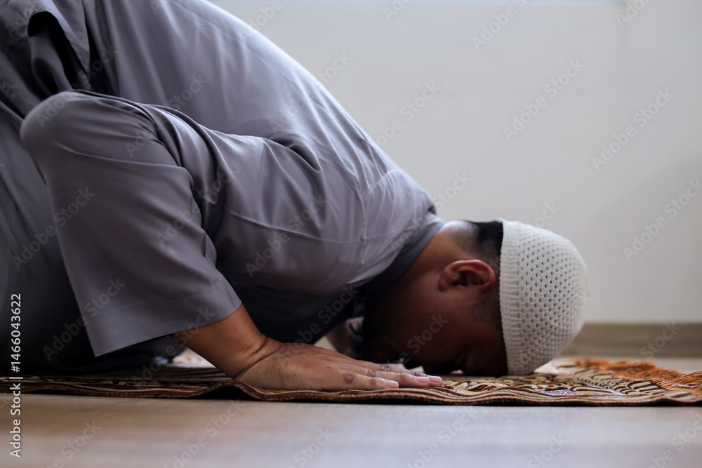 Fototapeta premium Side View Of Muslim Man Praying In Mosque With Prostration Salah Movement
