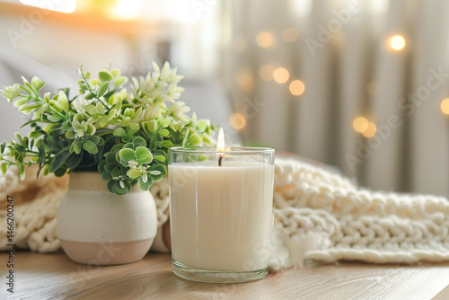 Cozy candlelit scene with a clear glass candle and a small vase with greenery