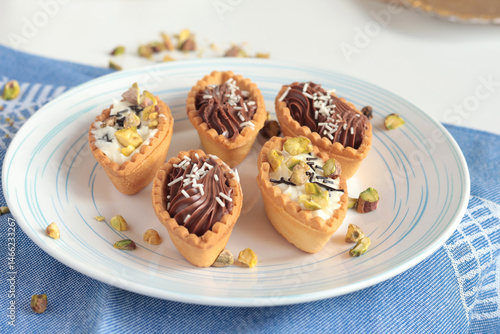 Wallpaper Mural Sand dough tartlets with chocolate filling, pistachio nuts on white plate. Dessert for party, holiday.  Torontodigital.ca