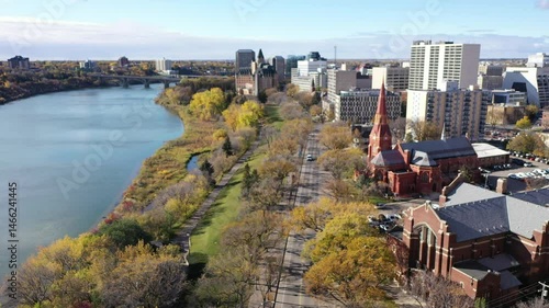 City view with a river and a large red building. The city is bustling with activity and the buildings are tall