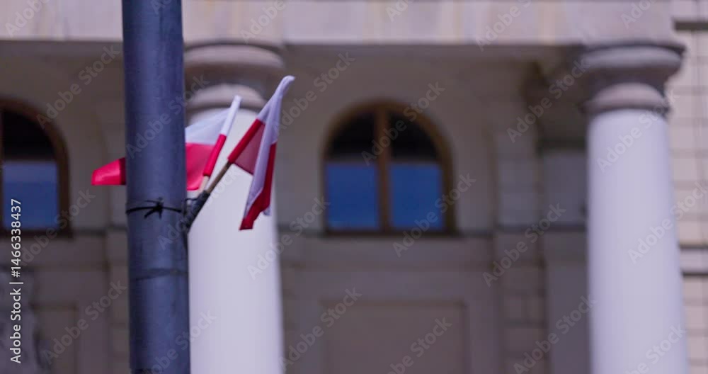 Polish Flags on a Pole Set Against a Dynamic Urban Background Incorporating Architectural Elements