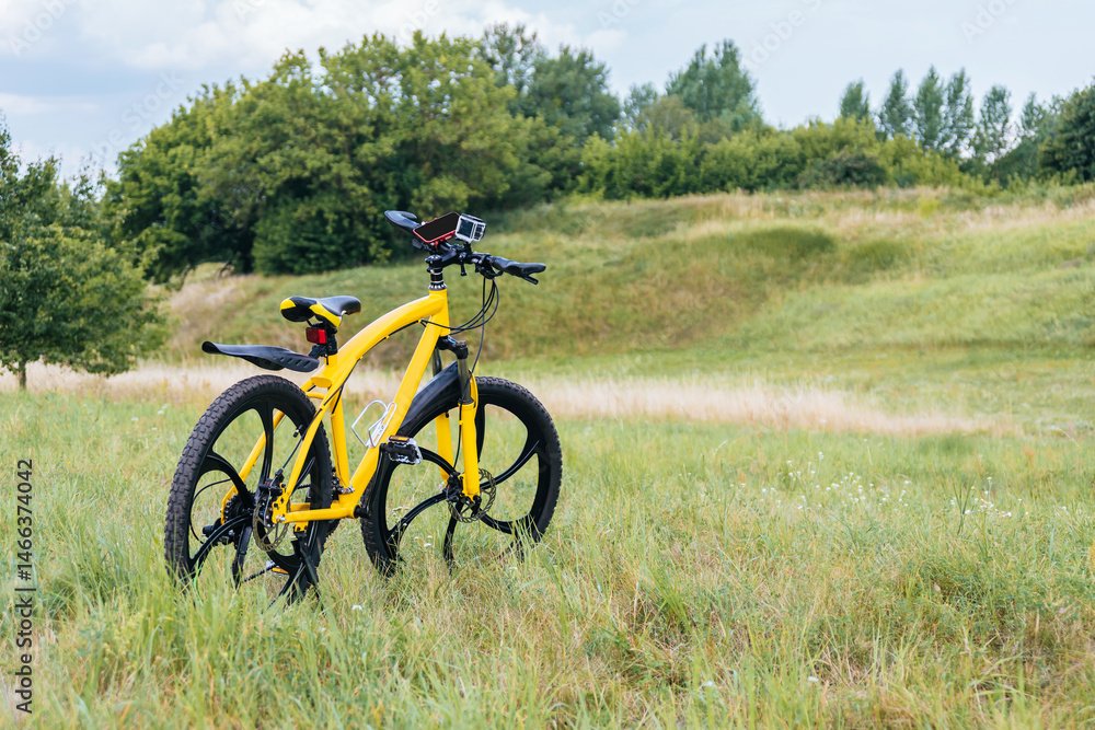 Obraz premium A yellow mountain bike costs green grass. nature background.