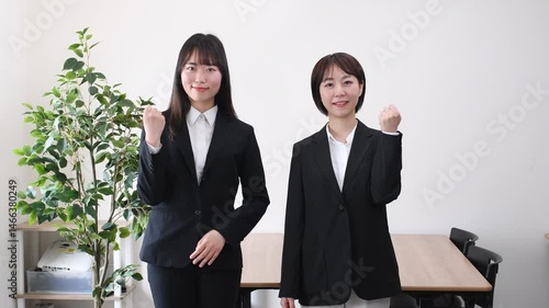 ガッツポーズするスーツ姿のアジア人女性