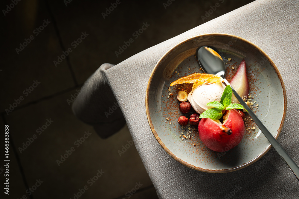 Ice cream and pear in wine on plate and spoon on light background, space for text