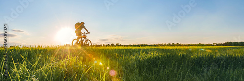 Long Banner, Cyclist riding a bike in a field.