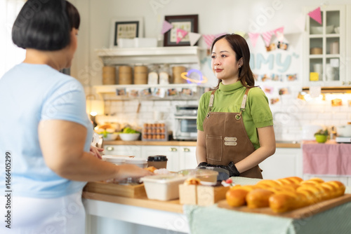 Small business owners are selling .Handsome young caucasian waiter servicing the customer with swiping machine in a cafe. Cashless contactless payment with credit debit card. E-banking .